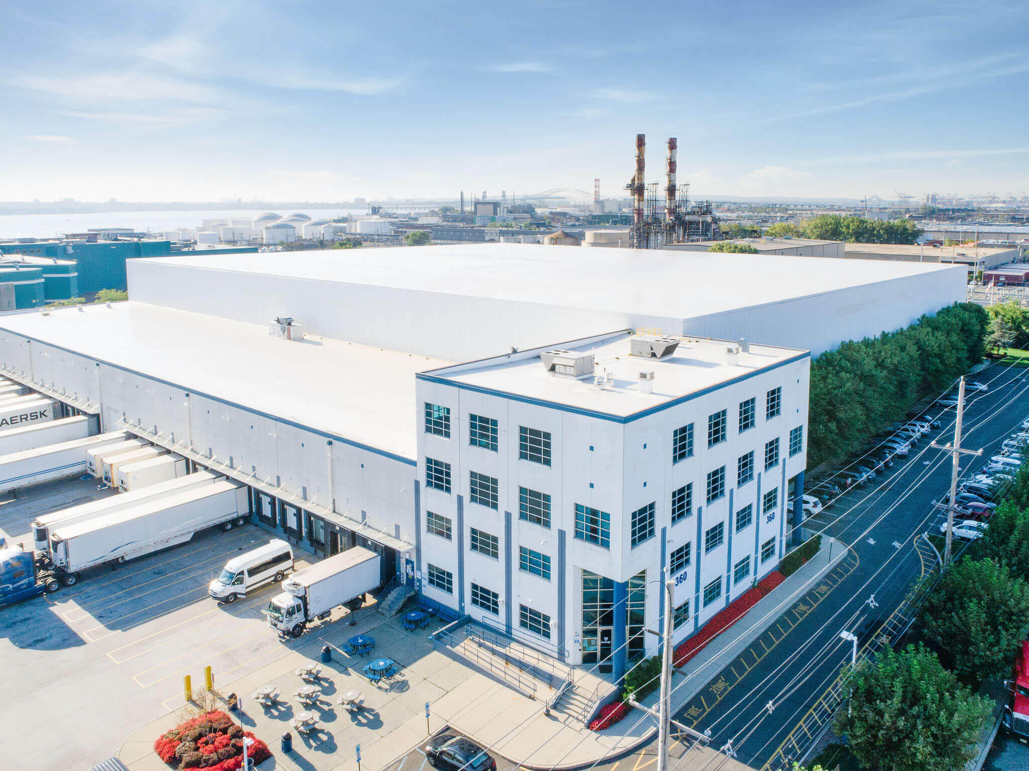 An aerial view of a large Airsun Express cold storage warehouse facility with parked trailers and a clear blue sky.