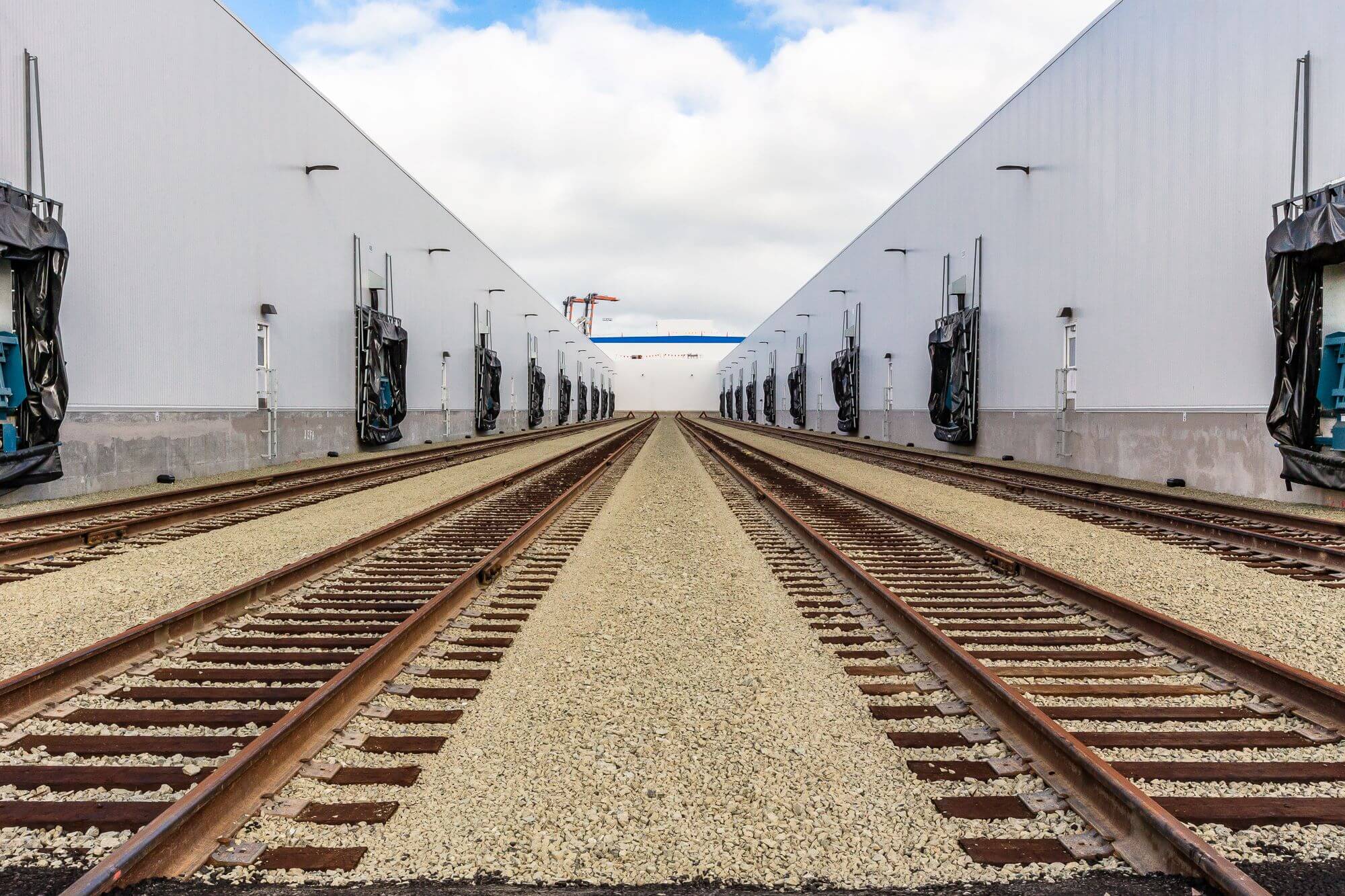 Train tracks leading to Airsun Express cold storage warehouse for moving and storing temperature-controlled food.