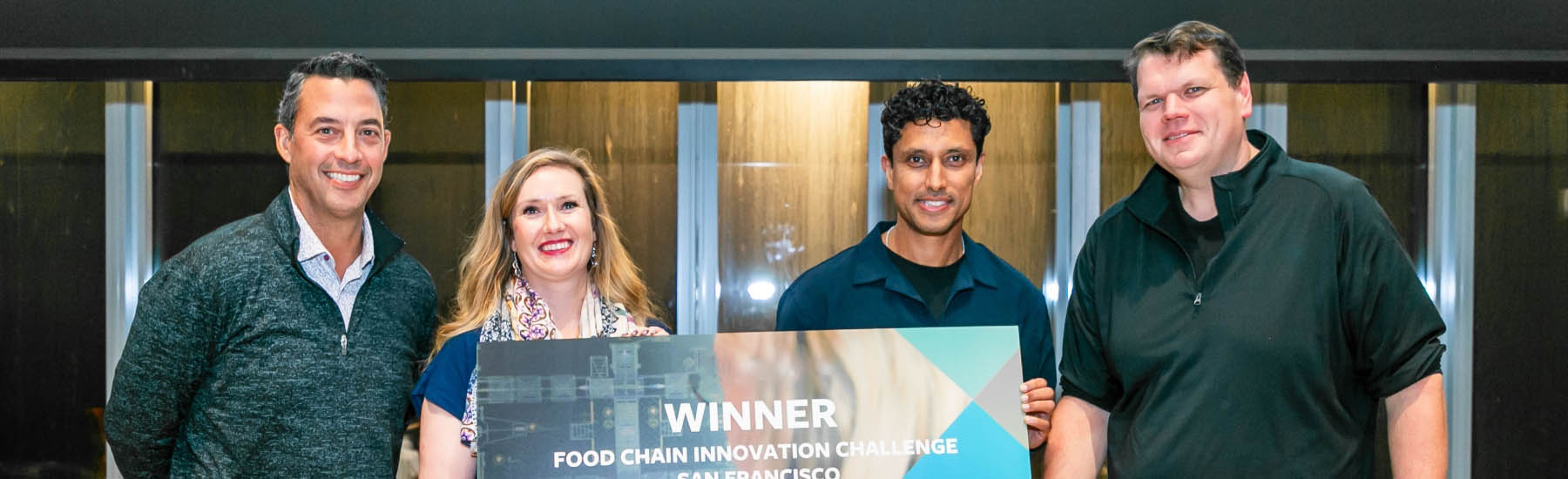 The winners of Airsun Express's Food Chain innovation Challenge hold a large check alongside company COO and Chief Data Scientist