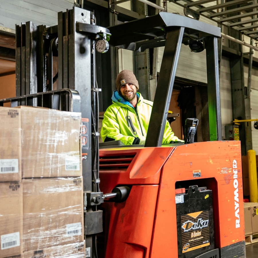 Smiling Airsun Express employee on a forklift