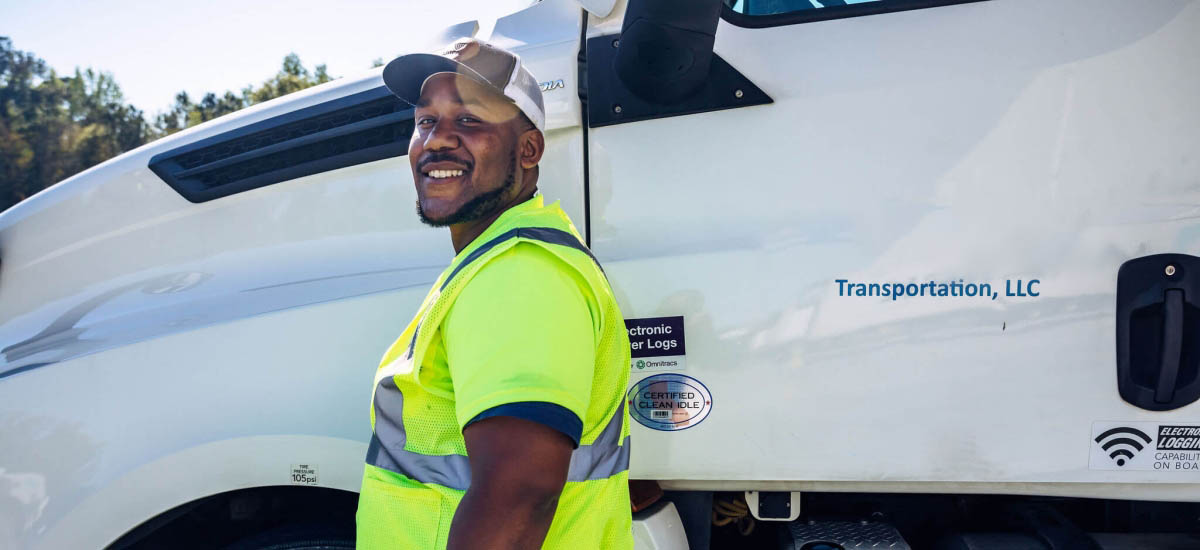 Smiling driver in high-visibility vest standing beside a Airsun Express Transportation truck, representing the dedicated workforce behind efficient food supply chain logistics.