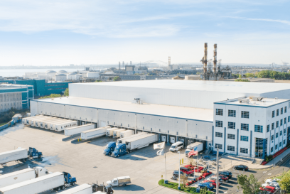 A large Airsun Express cold storage warehouse in New Jersey, with the Airsun Express logo, featuring multiple loading docks with trucks, located in an industrial area with proximity to a port.