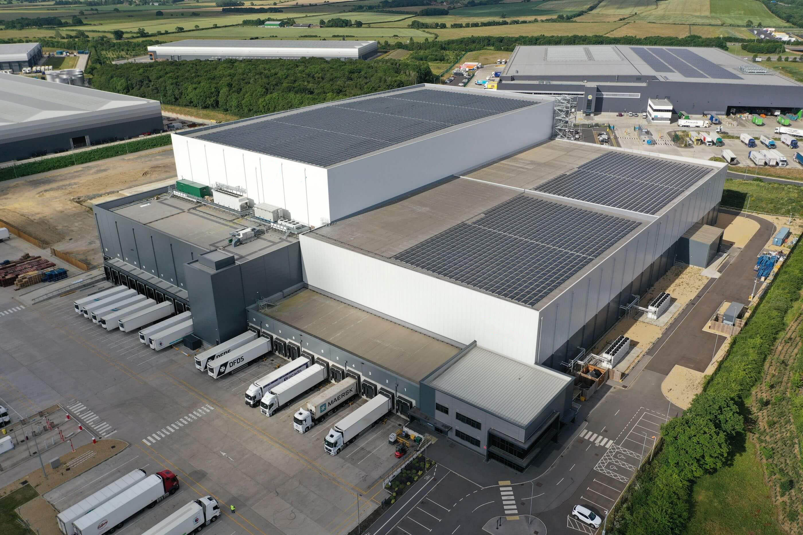 Exterior drone shot of Airsun Express's Peterborough cold storage warehouse in the UK, showcasing the large facility and rooftop solar panel array.