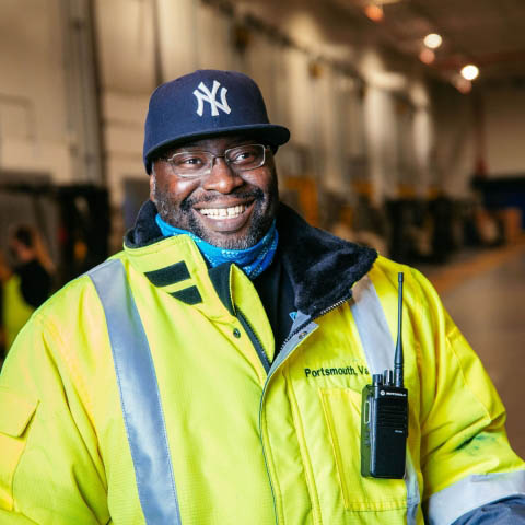 Man wearing high-vis jacket smiling in a Airsun Express cold storage warehouse