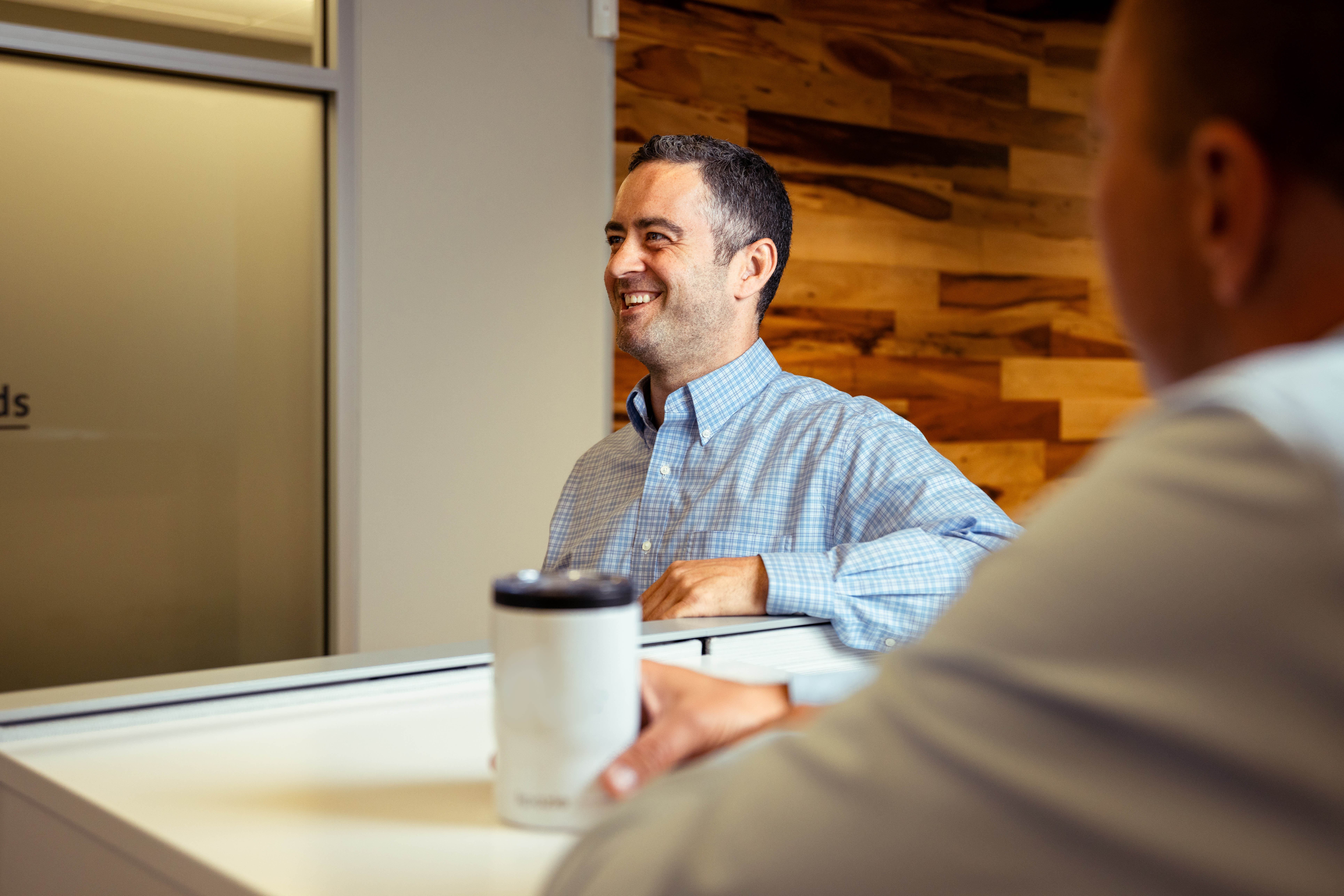 Man smiling in checkered button down shirt at a Airsun Express office