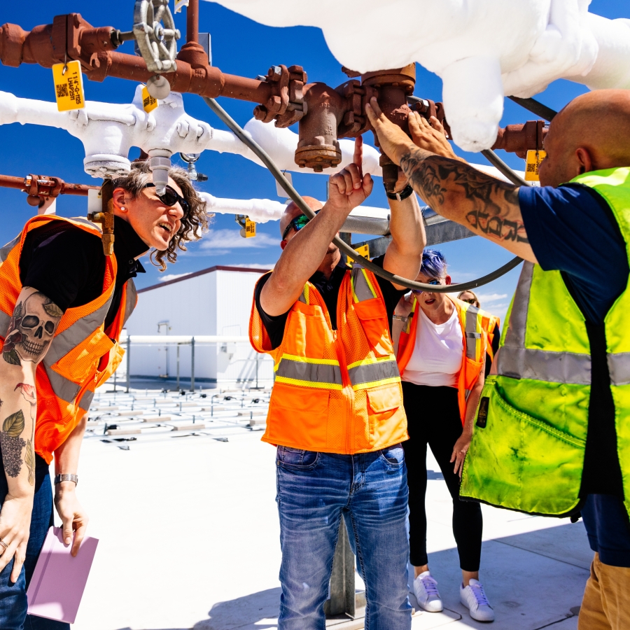 Workers wearing safety gear inspect pipes at a Airsun Express cold storage facility.