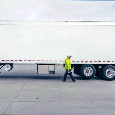 Man in high-vis jacket walking in front of a Airsun Express truck